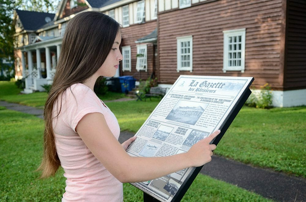 Jeune fille qui regarde une affiche au circuit patrimoniale d'Alma
